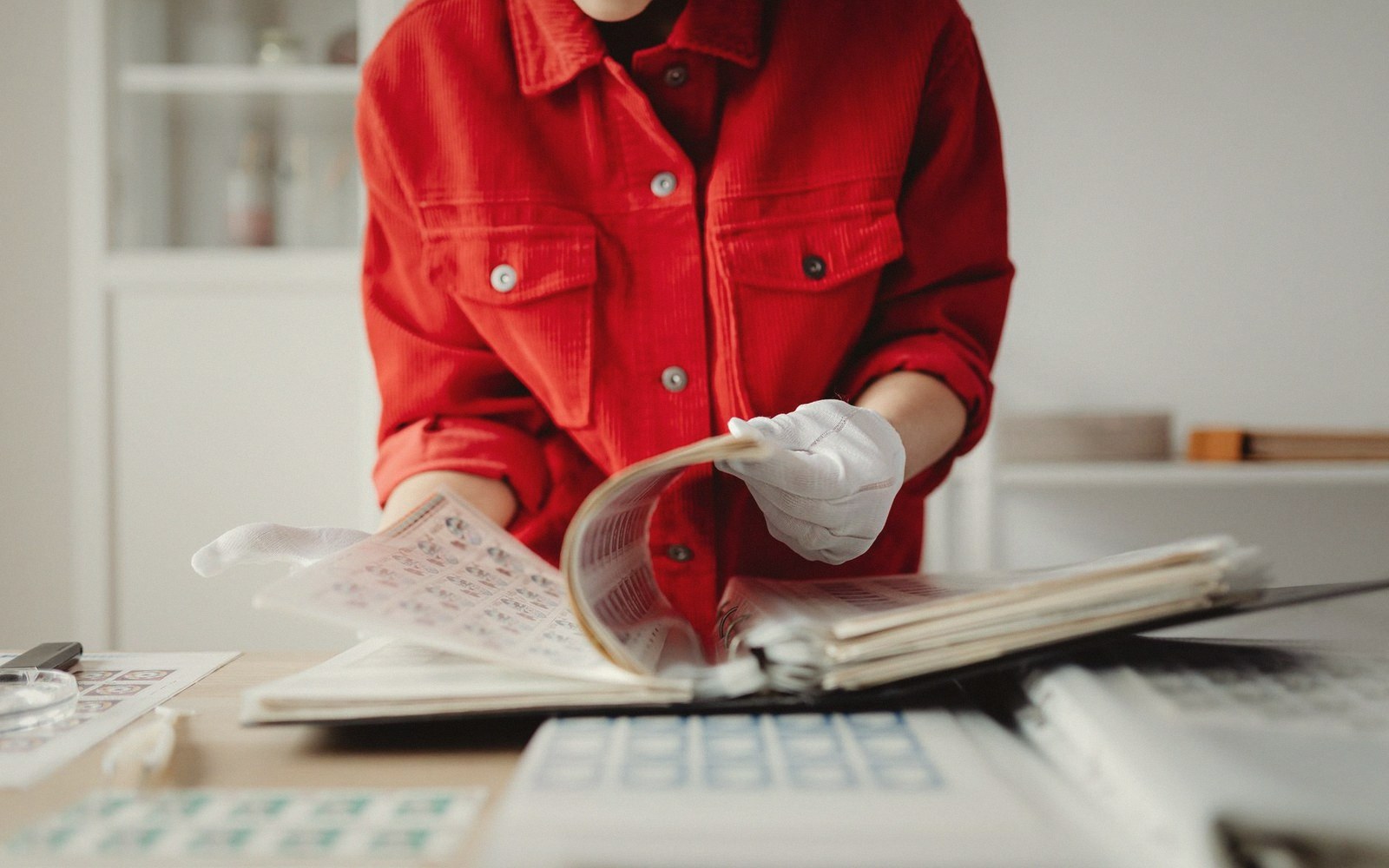 Gloved hands sliding a print into an archival sleeve